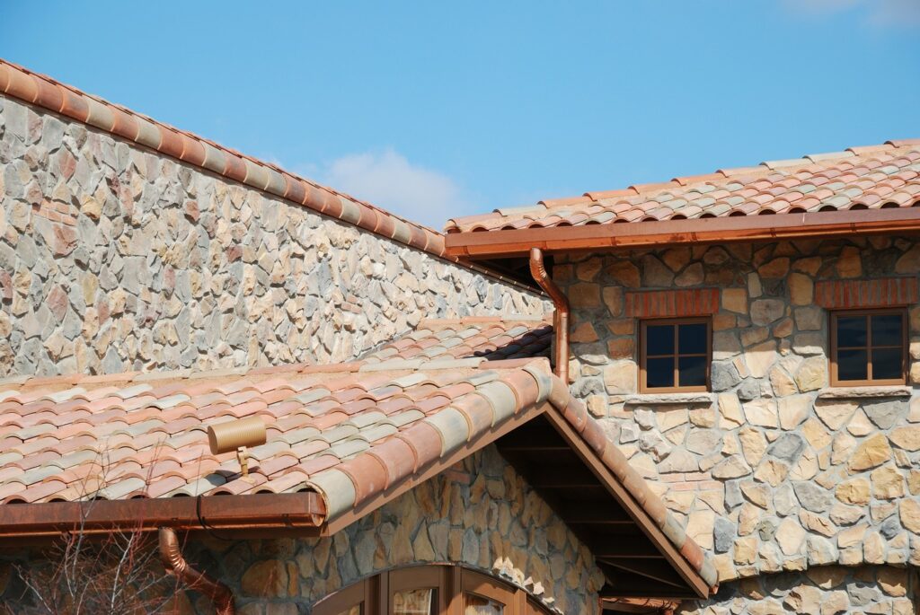 Beautiful stone built public building exterior over the blue sky background with tile roofing in Unionville, CT.