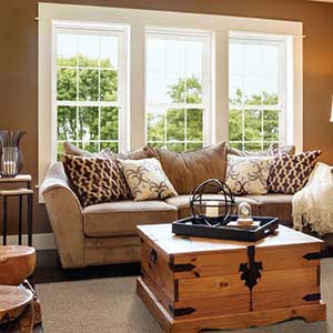 Cream colored Alside windows behind a sofa in a living room area