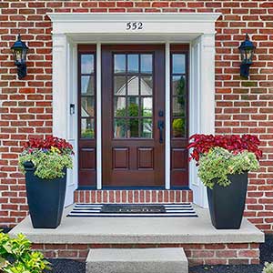 Front of a home with a brown Therma-Tru front door on a very small concrete porch