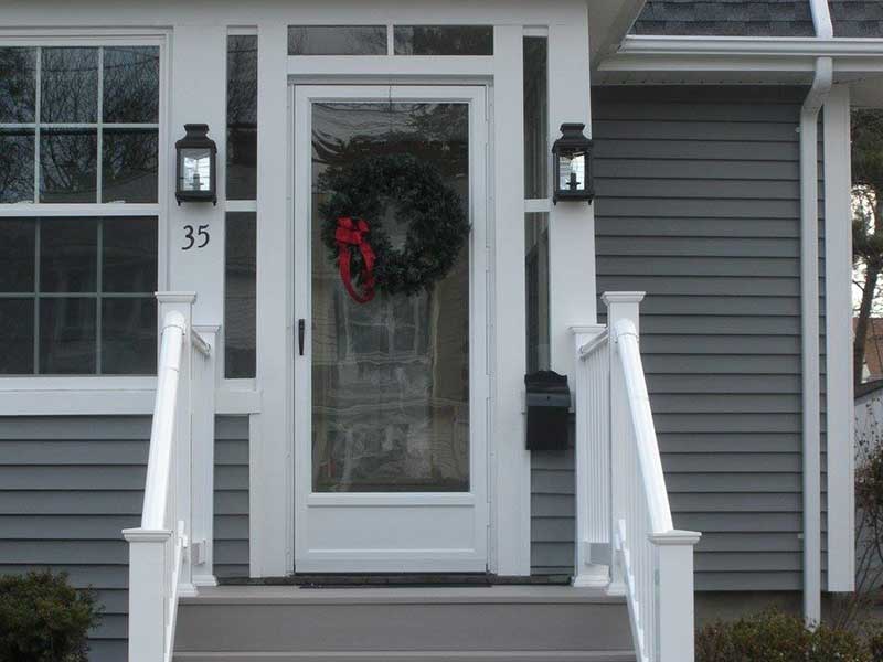A white front door on top of some stairs with white railing